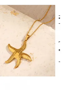Close-up of golden starfish pendant on thin chain over a textured stone surface