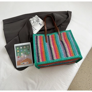Detail of colorful striped crochet tote bag with premium dark brown leather straps