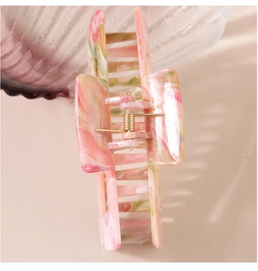 Detailed view of large marble texture hair claw clip with golden metal spring mechanism