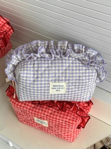 Detail of purple quilted gingham makeup bag with ruffled edges and fabric texture