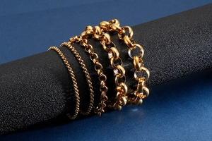 Detail view of various sizes of polished gold stainless steel O-link chains and bracelets