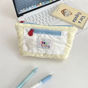 Detail of multi-layer pencil case showing vibrant zipper pockets and canvas texture