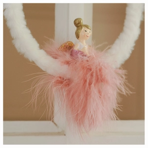 Detail of plush angel ornament with soft pink feathers and white ring for Christmas tree