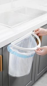 Wall-mounted kitchen trash can with fixation ring for securing bags on gray cabinet