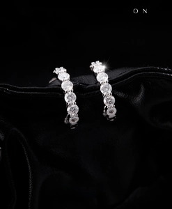 Détail macro de boucles d'oreilles créoles en argent serties de moissanites