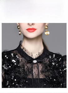 Detail of high neck black lace dress with sequin floral embroidery and pearl bow accent