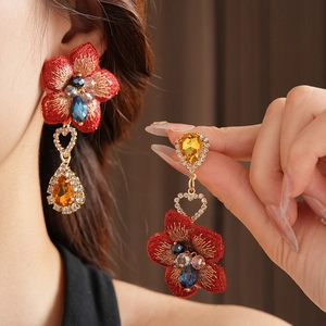 Détails de boucles d'oreilles fleurs brodées rouges avec strass et accents dorés