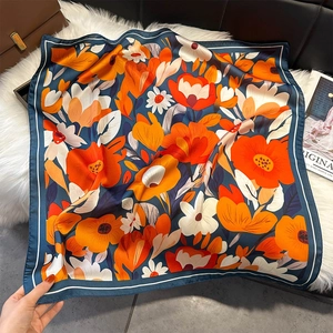 Elegant floral square silk scarf with bold orange and yellow blossoms on deep blue base