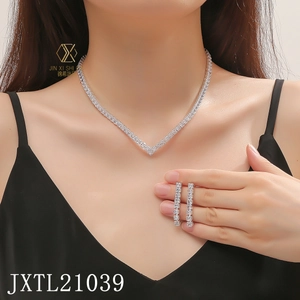 Close-up of V-shaped zircon necklace and drop earrings set on a model in a black dress