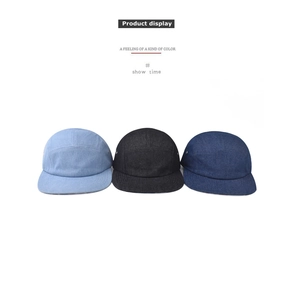 Detail of 5-panel denim camper hats in light blue, dark blue, and black with metal eyelets