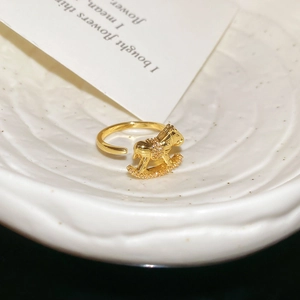 Detailed close-up of a golden rocking horse ring featuring intricate zircon micro-paving