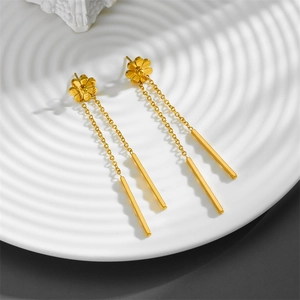 Elegant gold daisy floral stud earrings with long tassels on white textured plate