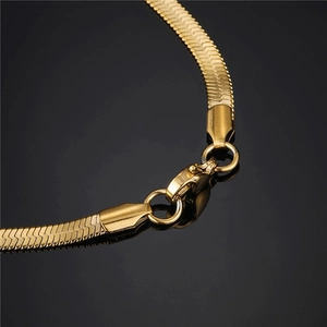 Detail of golden stainless steel herringbone chain featuring a secure lobster clasp