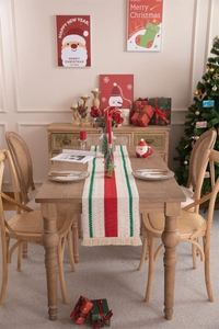 Detail of knit Christmas table runner with red and green stripes and decorative tassels