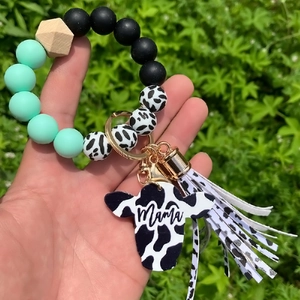 Detail of beaded keychain bracelet with cow print tassel and Mama cow head pendant
