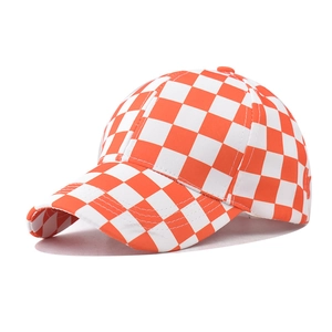 Vista lateral de la gorra de béisbol con patrón de damero naranja y blanco y visera curva