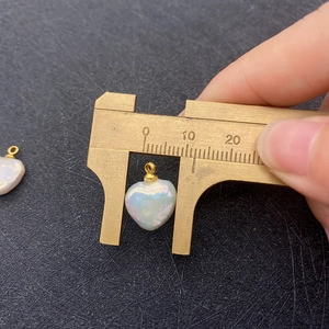 Macro shot of an irregular heart pearl pendant with gold bail measured at 14mm width