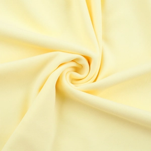 Macro shot of pale yellow fabric texture with elegant spiral draping for dresses