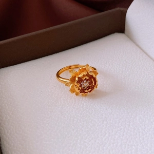 Détail d'une bague florale plaquée or avec centre en zircon sur une boîte à bijoux blanche