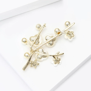 Détail macro d'une broche jasmin d'hiver avec perles d'eau douce et zircons brillants