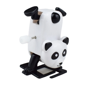 Detail of wind-up panda toy performing a headstand with white clockwork key