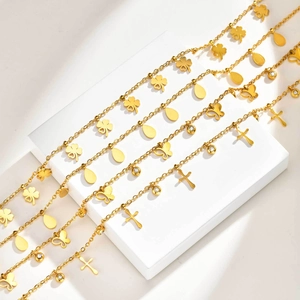 Detailansicht vier goldener Edelstahlketten mit Kleeblatt, Schmetterling und Kreuz