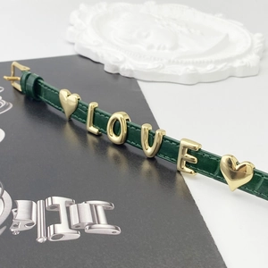 Detail of green leather strap with gold LOVE letter sliders and heart charms