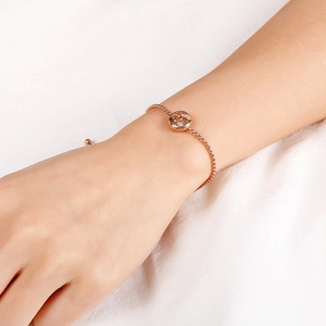 Close-up of rose gold zodiac bracelet with crystal pendant on a wrist
