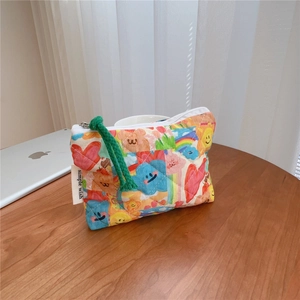 Detailed close-up of a quilted floral mini pouch with colorful graffiti on a wooden desk