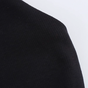Gros plan sur l'épaule de la robe noire montrant la texture du tissu et les détails de couture