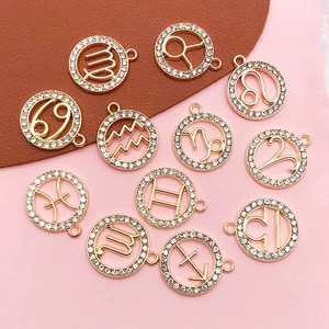 Macro shot of twelve gold zodiac pendants set with sparkling white rhinestones on leather