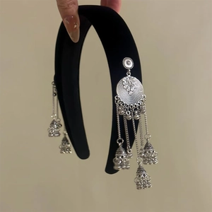 Close-up of velvet headband featuring ethnic silver bell tassels and vintage charms