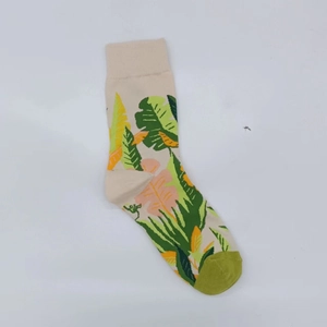 Close-up of tropical leaf pattern and ribbed knit texture on a beige cotton sock