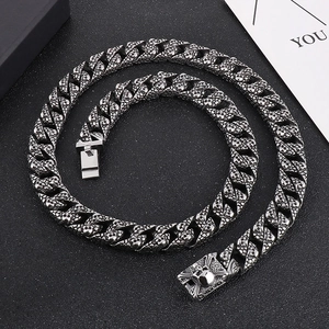 Detailed view of silver stainless steel Cuban link necklace with gothic skull patterns