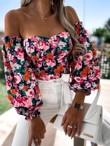 Detail of blue floral off-shoulder top with puff sleeves and vibrant flower patterns