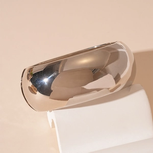 Polished metallic wide cuff bracelet with irregular geometric design and mirror finish