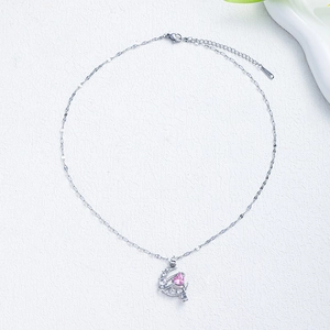 Detail of silver crescent moon necklace with pink heart pendant and sparkling crystals