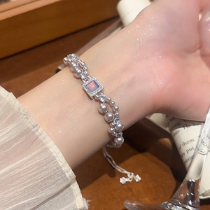 Détail macro du bracelet à perles double rang avec zircon carré et cordon réglable