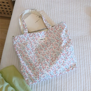 Détail du sac cabas en coton fleuri avec étiquette Simple Wish sur tissu matelassé