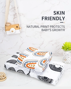 Detail of soft muslin cotton baby blanket featuring colorful rainbow patterns and skin-friendly texture