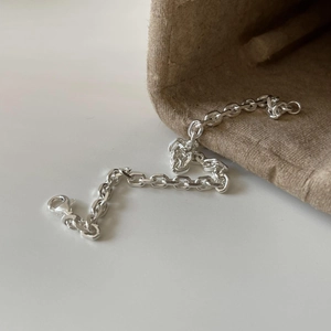 Modern S925 sterling silver chain bracelet with lobster clasp on a textured fabric