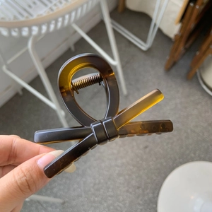 Detail of amber bow hair claw clip made of acetic acid with polished tortoiseshell texture