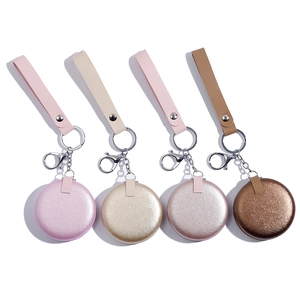 Row of four colorful glittery circular compact mirrors with leather handles and keychains