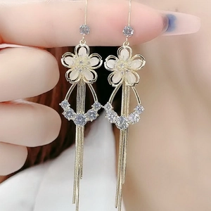 Golden tassel drop earrings with white cat-eye flowers and sparkling rhinestones