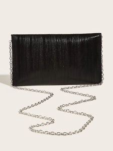 Detail of black textured evening clutch with pleated finish and silver chain strap