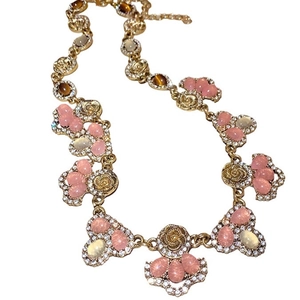 Luxurious gold floral necklace set with pink gemstones and shimmering crystals