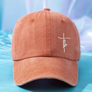 Detail of Faith embroidery and white cross on orange washed cotton baseball cap