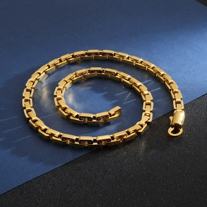 Detailaufnahme einer goldenen Kette mit quadratischen Gliedern und poliertem Verschluss