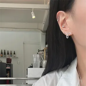 Detailed close-up of 925 sterling silver minimalist spiral stud and ear cuff on ear