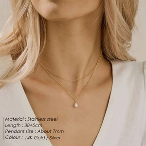 Double-layered stainless steel necklace with pearl pendant shown on model neck